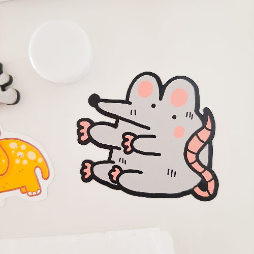 Hauska magneetti jääkaapin ovessa. Magneetti on rotta, jolla on raajat sojossa halia varten ja jonka ilme näyttää hieman tukalalta.