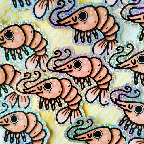 Kuvassa on katkaraputarra, jolla on glitteriset reunukset. Katkaravulla on hassu ilme ja se on vaaleanpunainen.