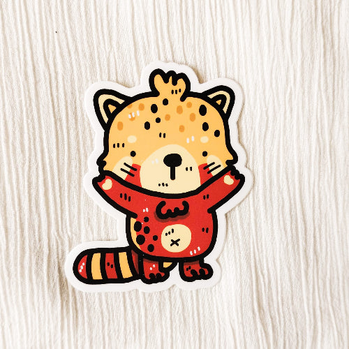 Kuvassa on kultapandatarra. Kultapandassa on punaista ja oranssia. Sen kädet ovat levällään valmiina halaukseen.