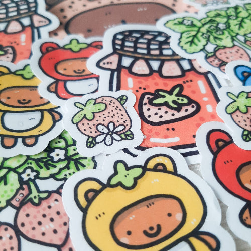 Kuvassa on monta tarraa. Tarrojen teemana on karhut ja marjat, etenkin mansikat.