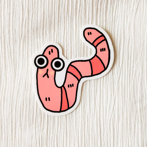 Kuvassa on hauska matotarra. Mato on pinkki ja sillä on suuret silmät.