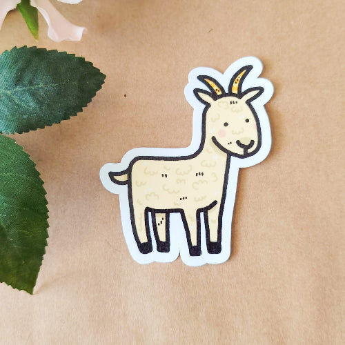 Kuvassa on hauska vuohitarra. Vuohella on kiiluvat nappisilmät ja mahtavat keltaiset sarvet.