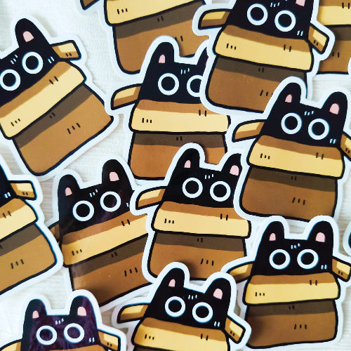 Kuvassa on kissatarra. Kissa istuu tyytyväisenä ruskean pahvilaatikon sisällä.