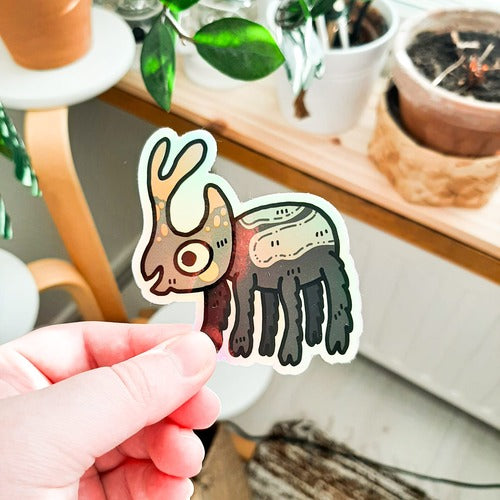 Vedenkestävä holograafinen tarra, joka on koppakuoriainen. Ötökällä on komeat sravet, kuusi karvaista jalkaa ja kiiltävä kuori. Se näyttää iloiselta.
