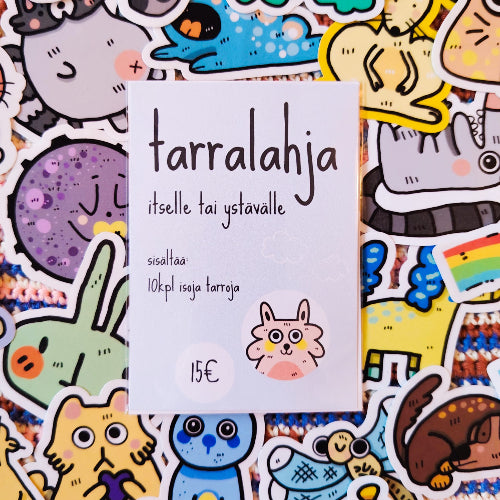 Kuvassa on tarrapaketti, jossa lukee: "tarralahja itselle tai ystävälle" sekä "sisältää 10kpl isoja tarroja". Taustalla on paljon erilaisia hauskoja eläintarroja.