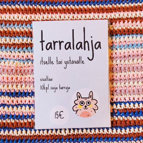 Kuvassa on vaaleansininen tarrapaketti raidallisen virkatun pinnan päällä.